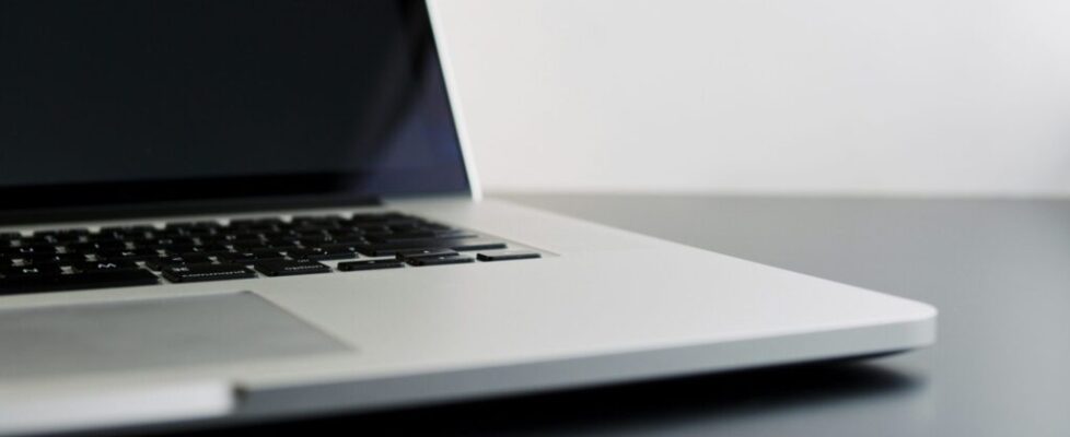 silver laptop computer on black table